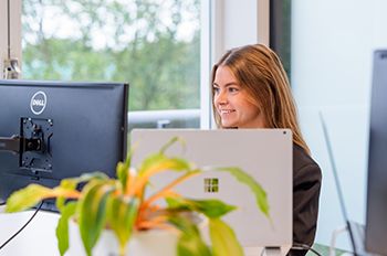 Medewerker werkt geconcentreerd achter bureau aan digitale strategie voor de customer journey